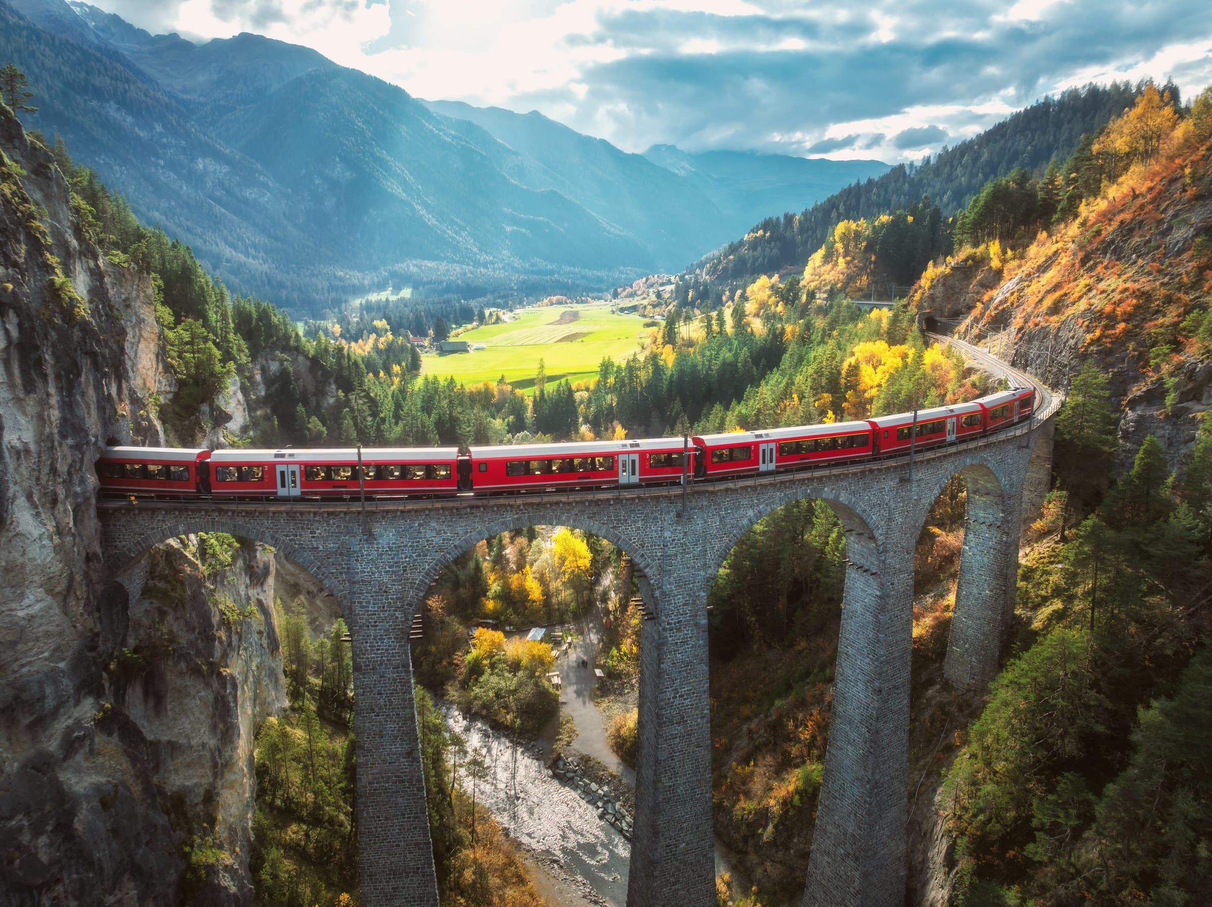 The Bernina Express crossing the Landwasser Viaduct through the Swiss Alps in autumn