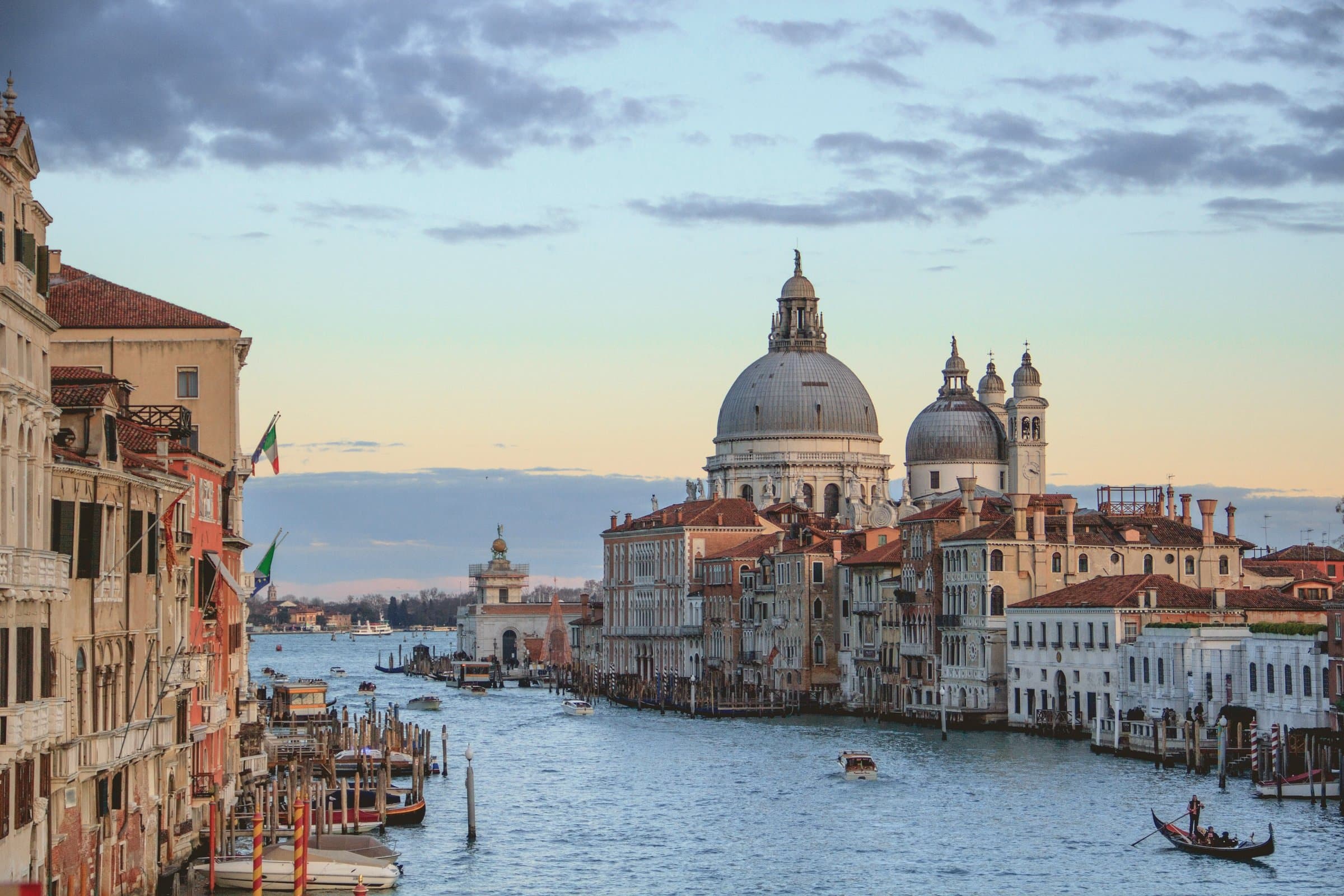 Sunset over Venice's Grand Canal with gondolas and the dome of Santa Maria della Salute, Italy