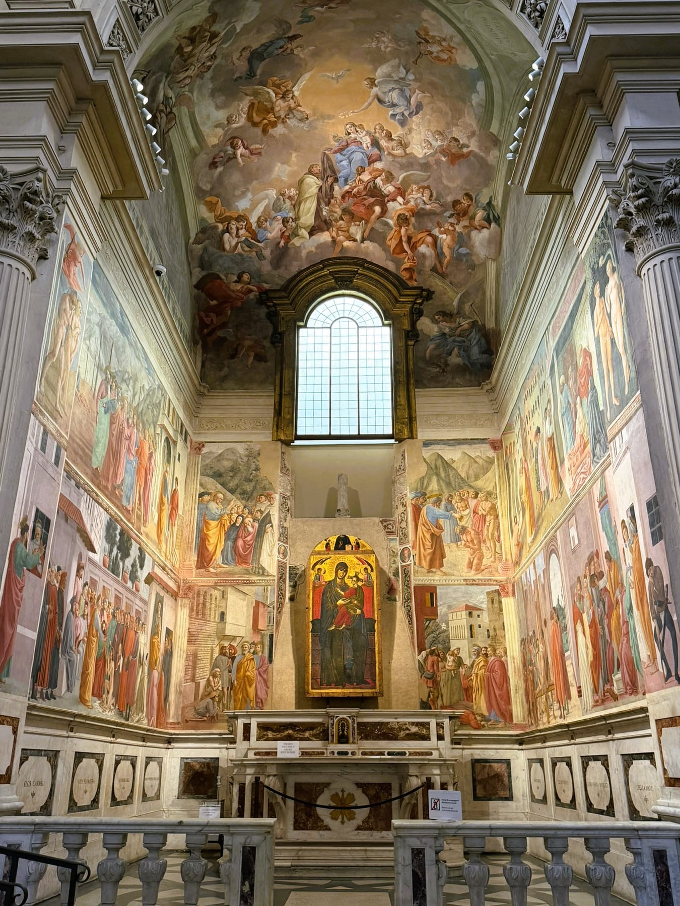 The Brancacci Chapel, with frescoed walls and a gold Madonna and Child above the altar