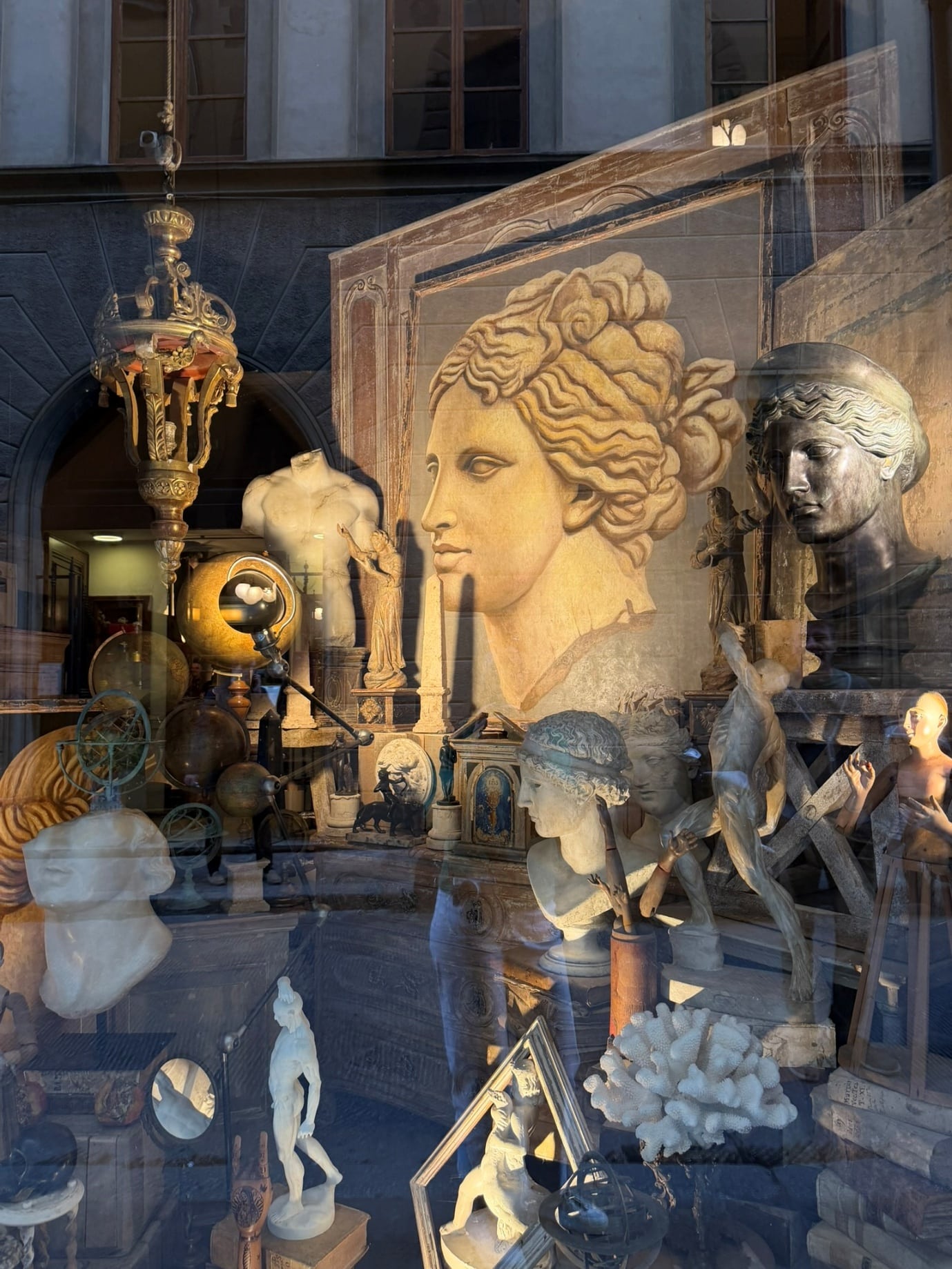 Classical busts, globes and a painted profile in an Oltrarno shop window