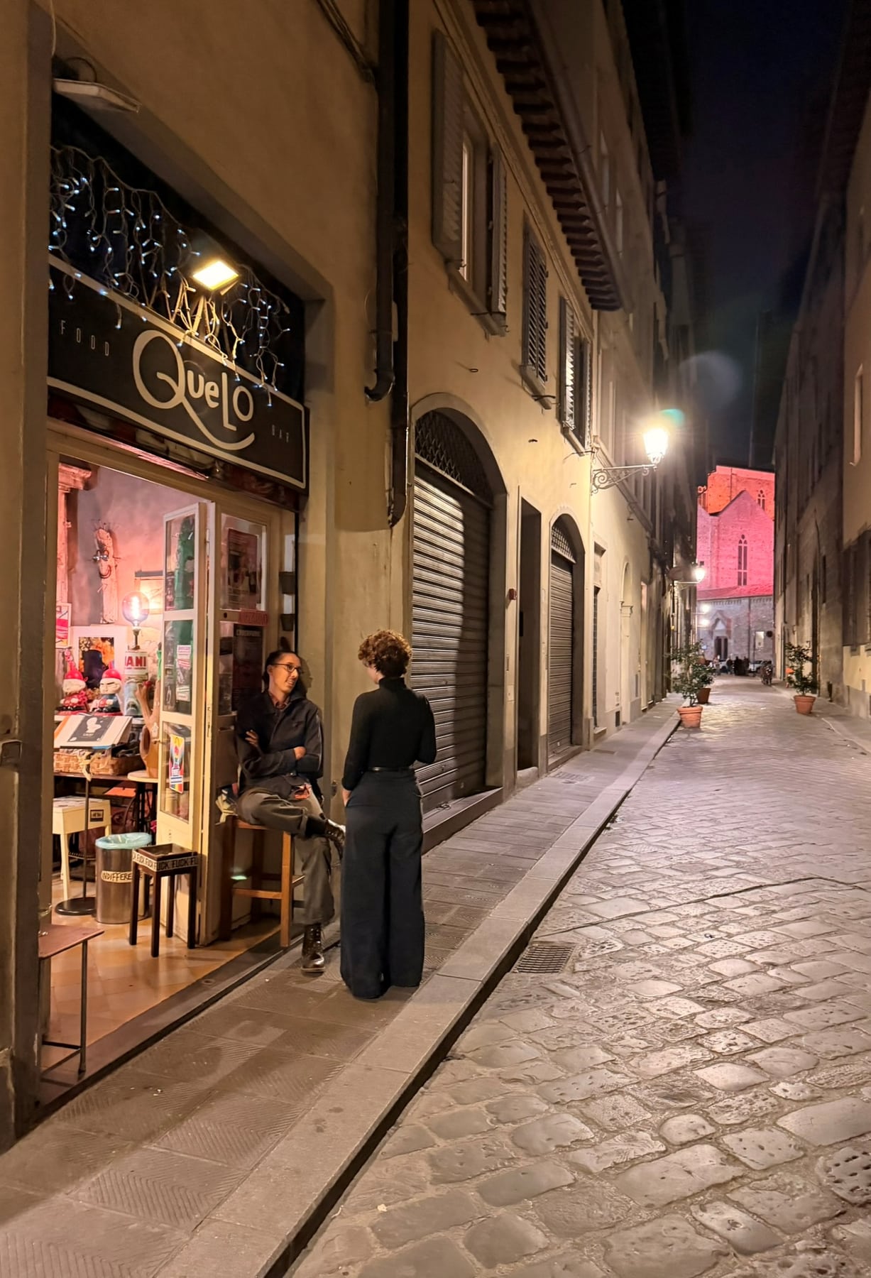 Quelo Bar at night on Borgo Santa Croce, with the church lit at the end of the street