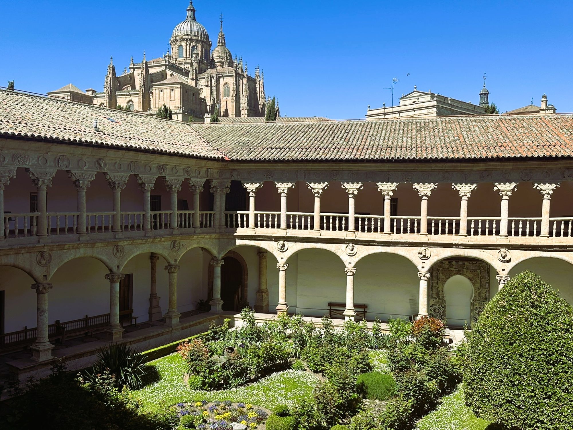 The cloister of the Convento de las Dueñas, with the dome of Salamanca's New Cathedral rising behind