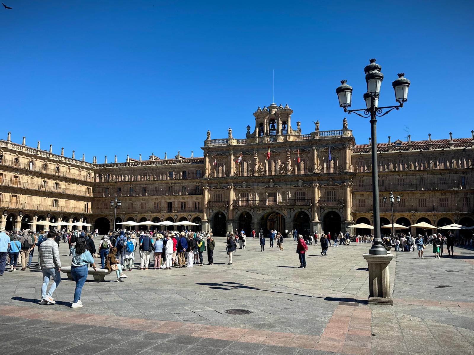 Salamanca's Plaza Mayor, with its arcaded sandstone façades under a blue sky
