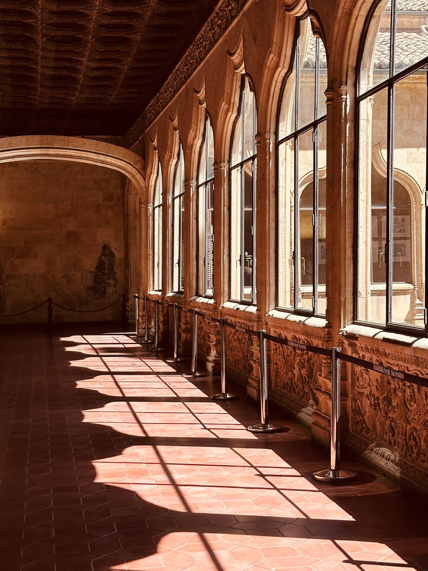 Sunlight falling through the arched windows of a gallery inside the University of Salamanca