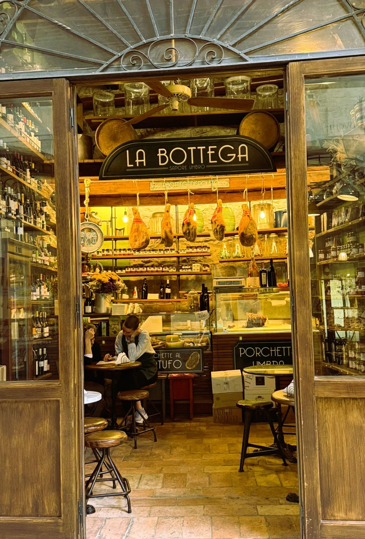 Hams hanging above the counter inside La Bottega di Spoleto