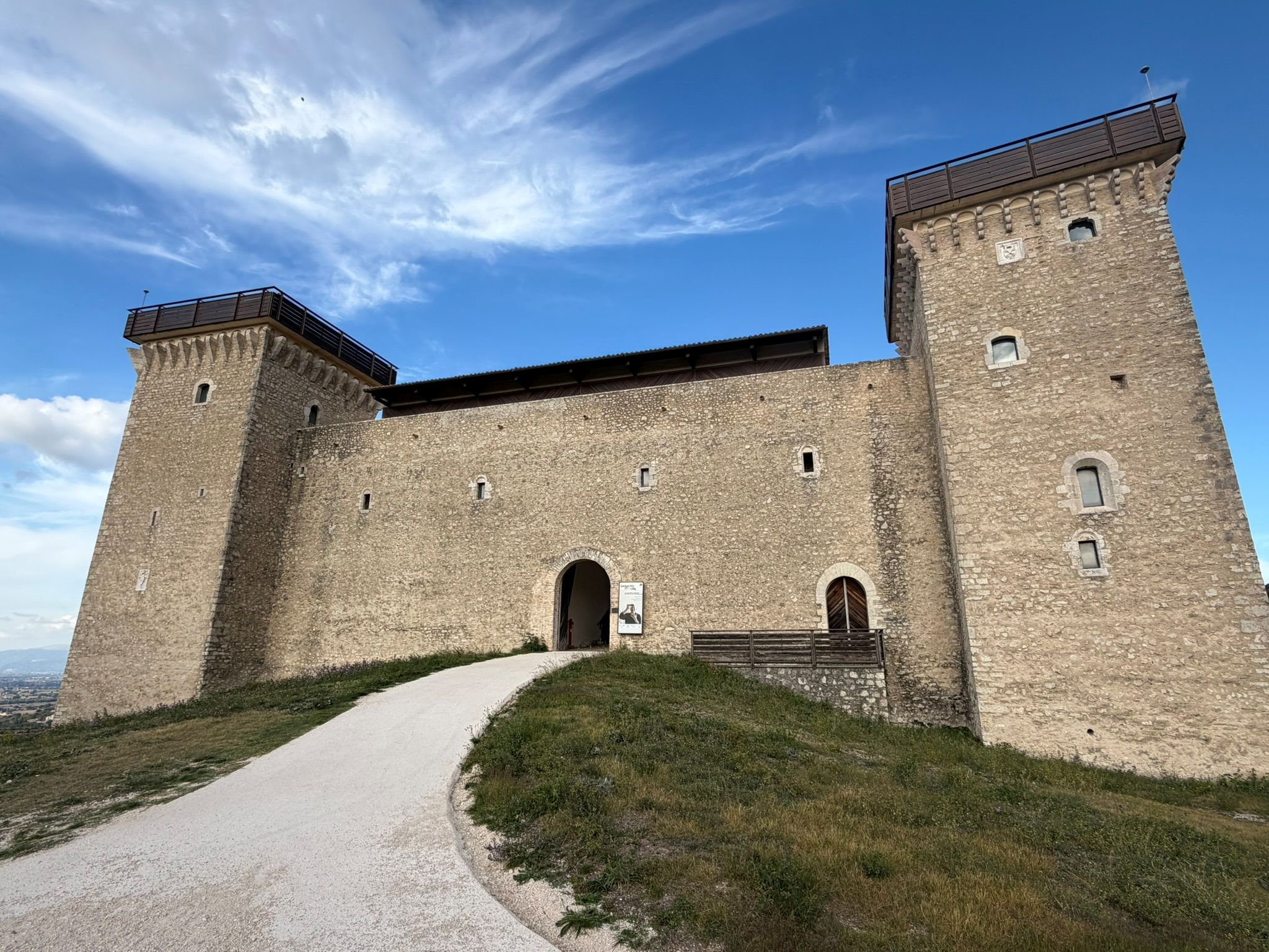The stone towers and arched entrance of the Rocca Albornoziana