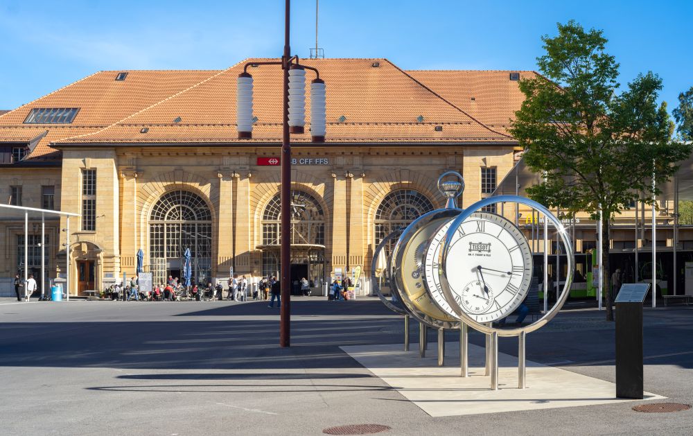 Oversized watch faces in the square outside the stone station at La Chaux-de-Fonds